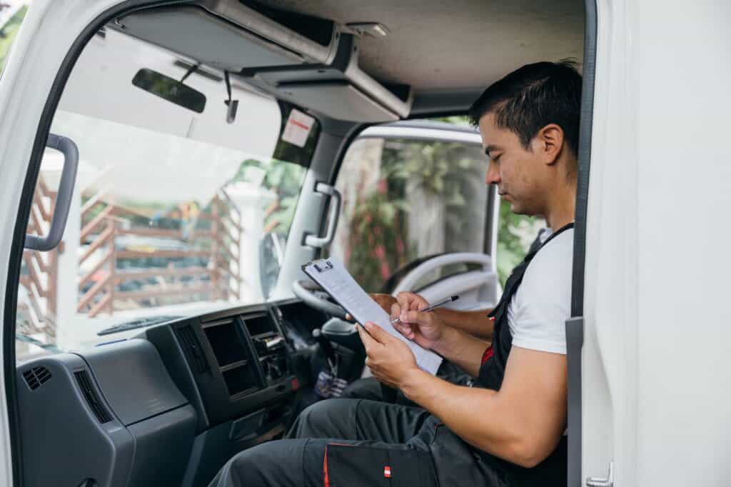 A side-view photo of the moving truck driver inside the truck