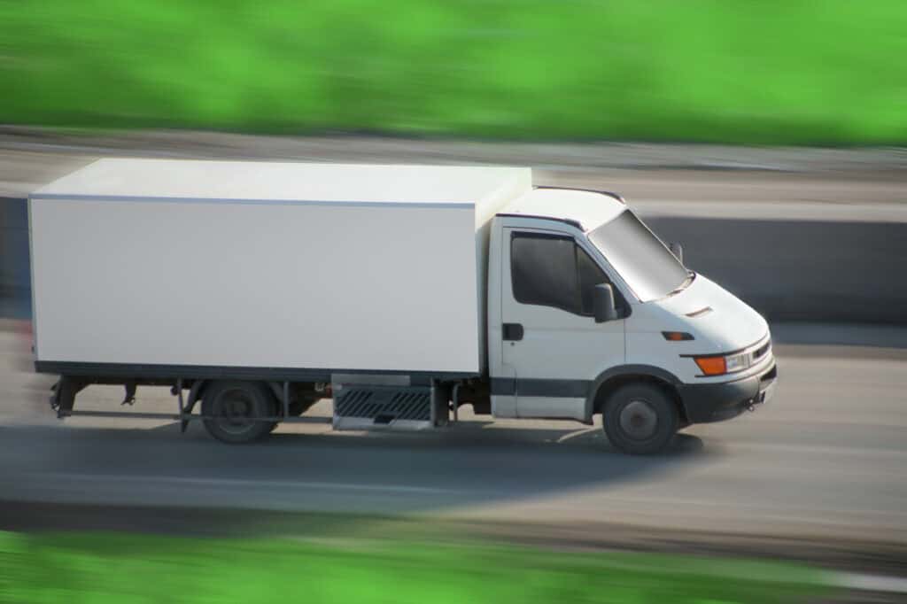 truck with white van moves on road