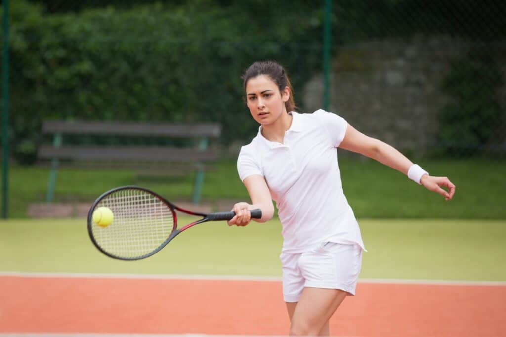 A tennis player is playing on the tennis court