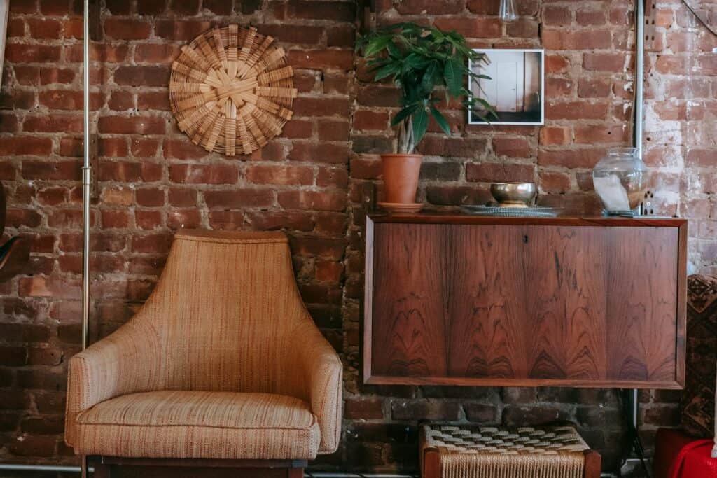 A chair and cabinet leaning on a brick wall