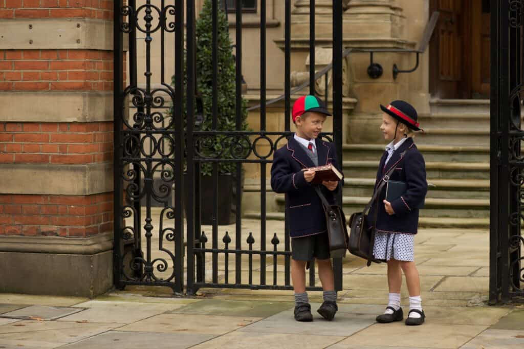 Young students talking and standing by the school gate